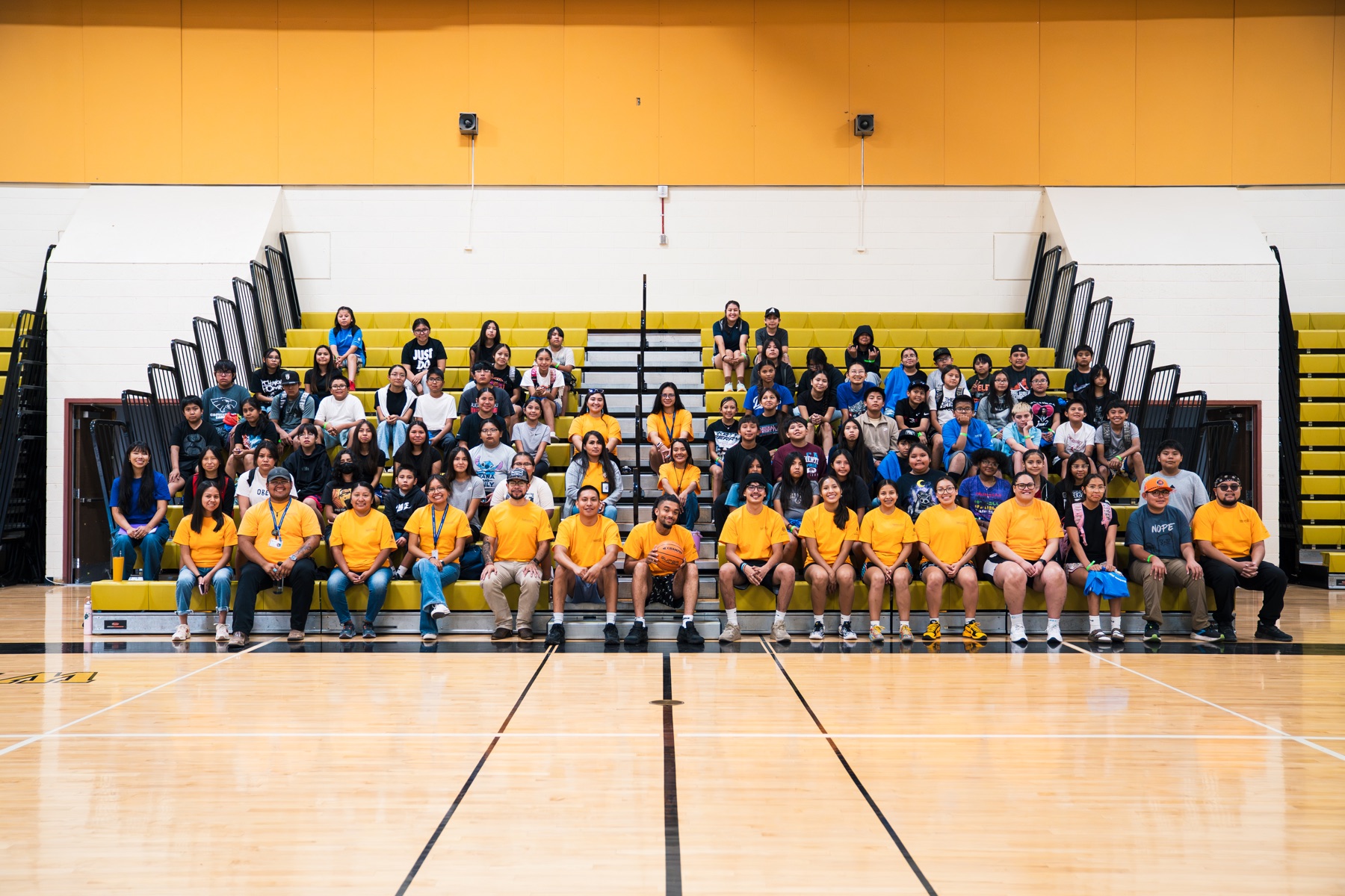 NativeVision Camp participants and staff gathered on gymnasium bleachers.
