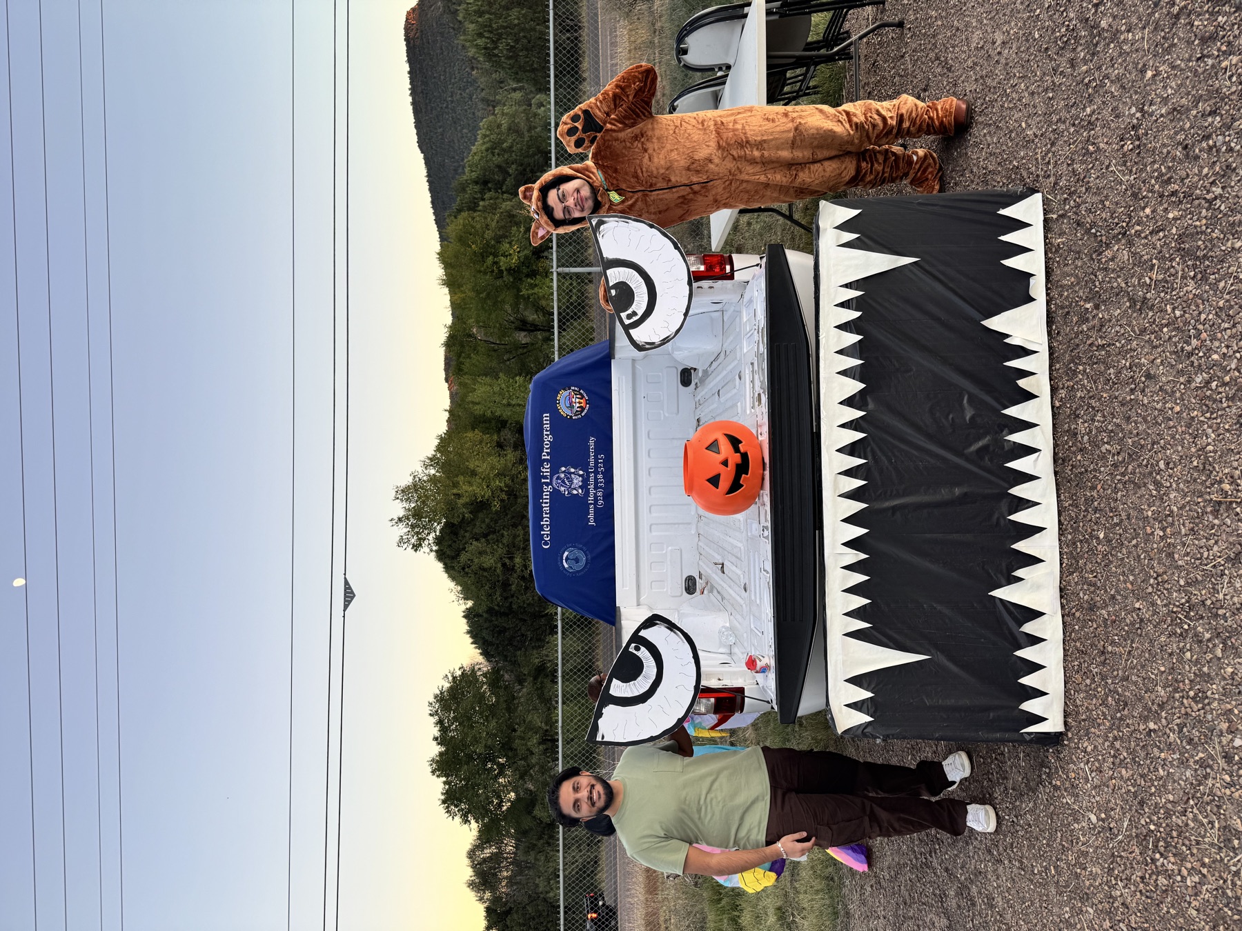 Community outreach participants beside a Halloween-decorated pickup truck at Trunk or Treat.