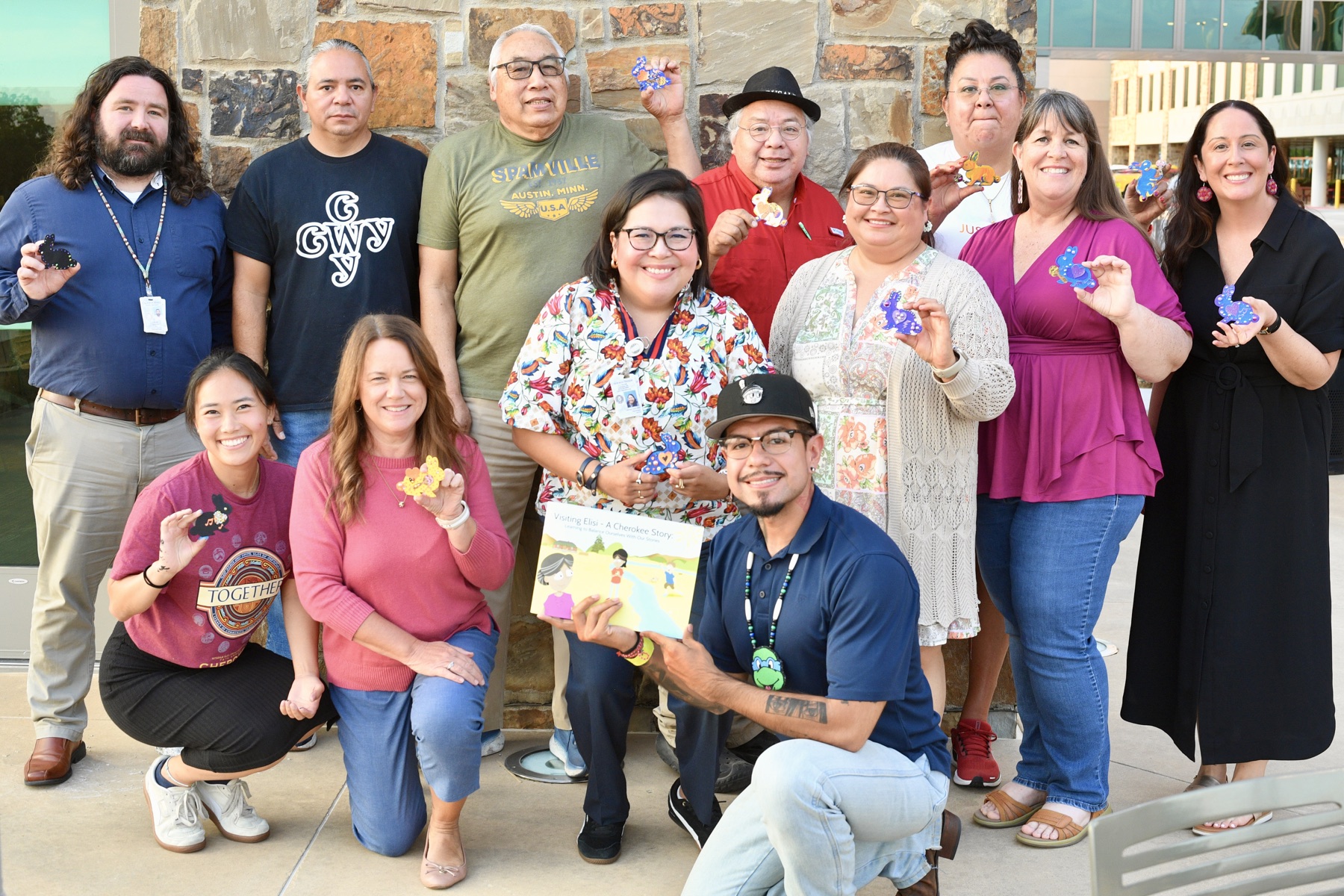 Cherokee Nation Storybook Project advisory board members holding artwork and a copy of Visiting Elisi.